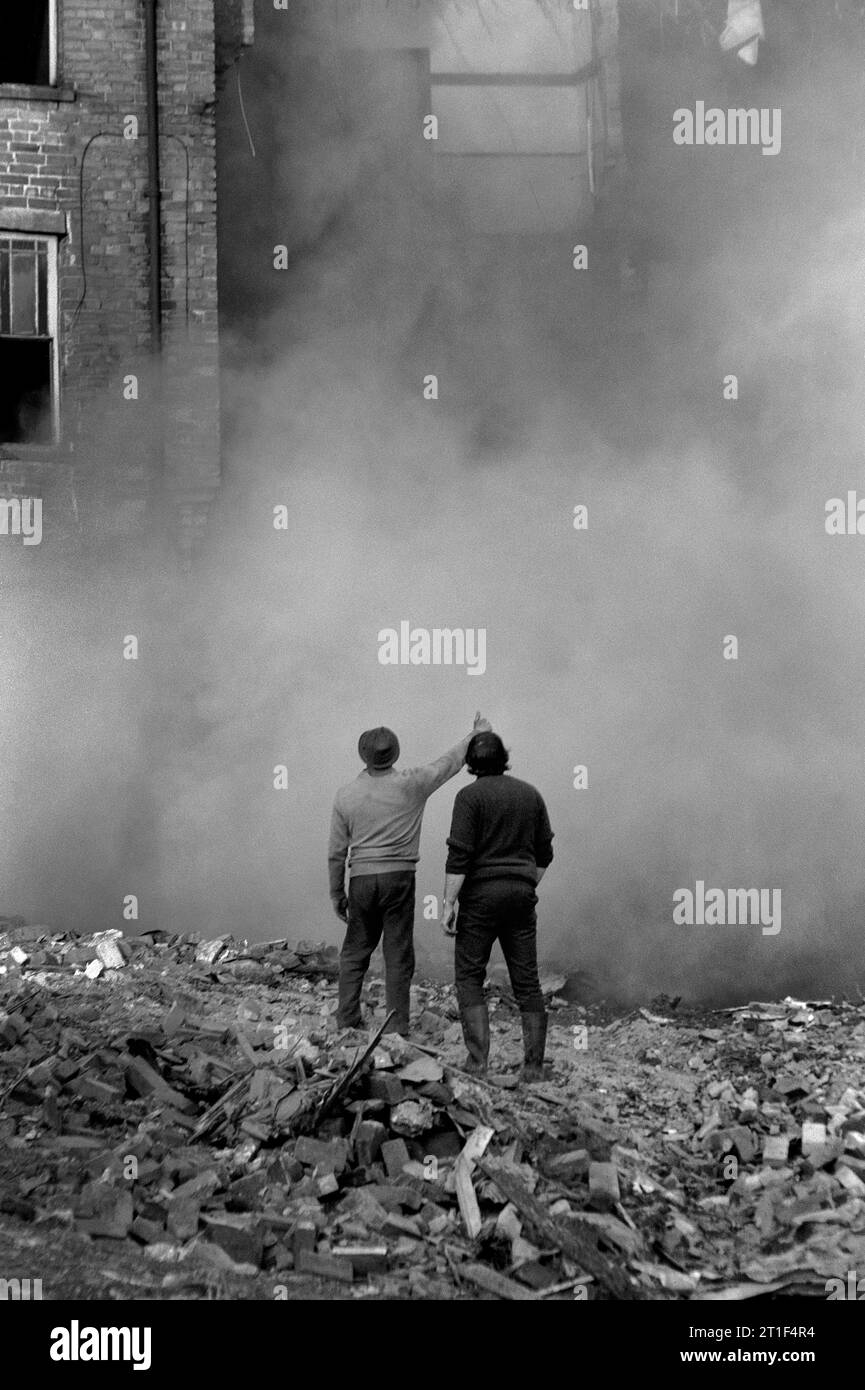 Workmen stood in a cloud of dust from house they are knocking down during the slum clearance and demolition of St Ann's, Nottingham. 1969-1972 Stock Photo