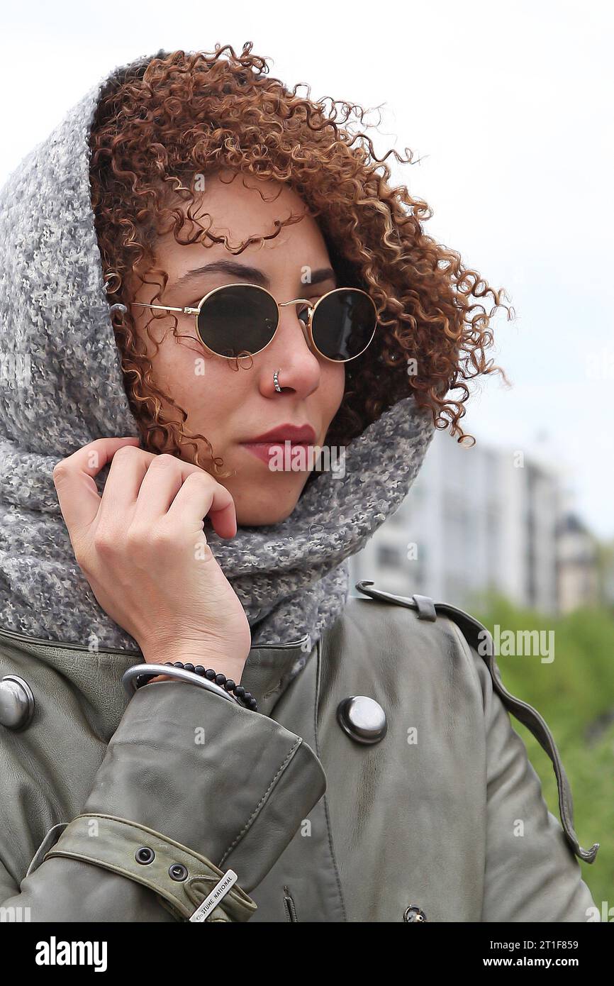 Curly hair woman wearing sunglasses posing in streets of paris Stock Photo