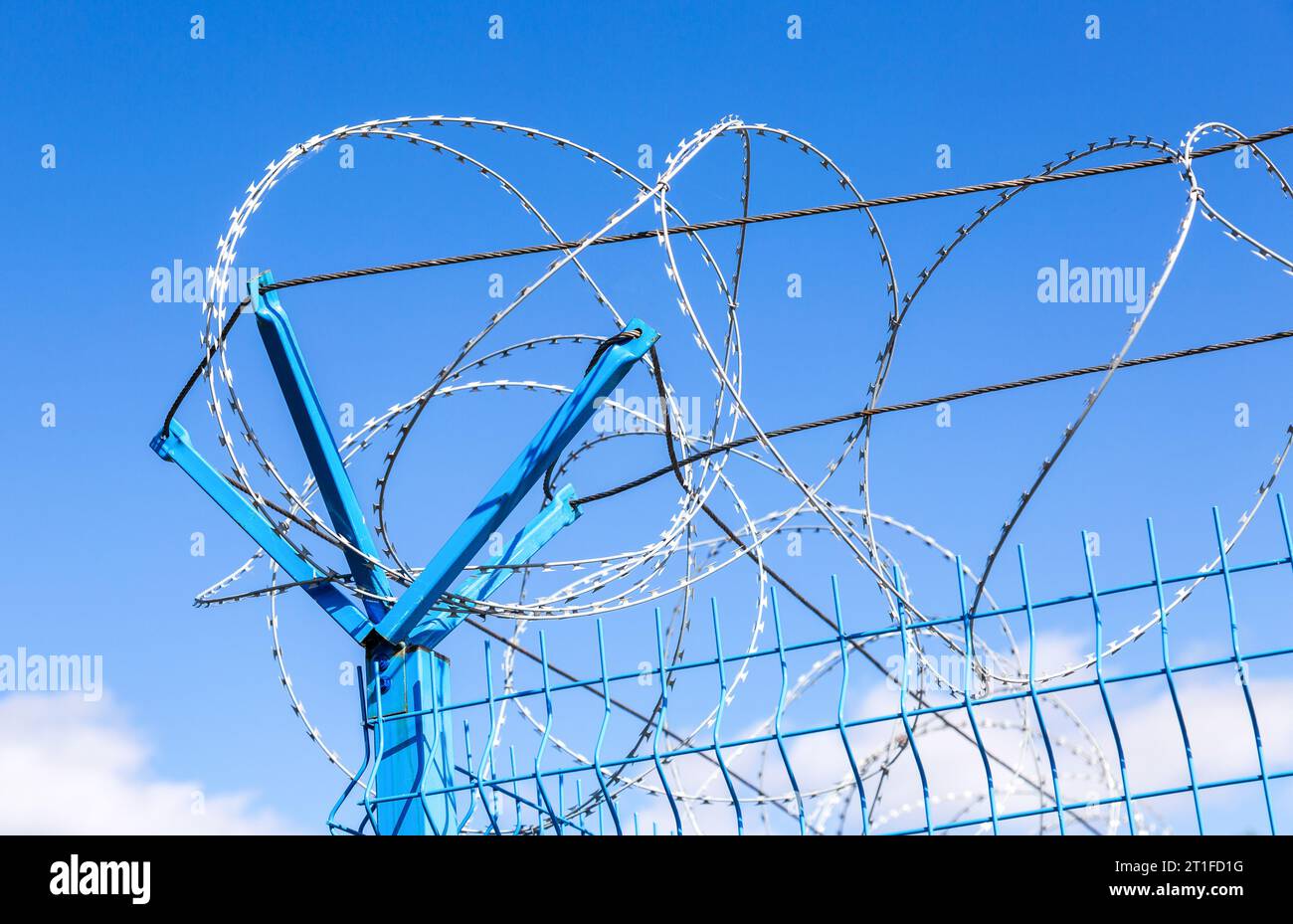 Barbed wire against the blue sky background. Protective fencing specially protected object of barbed wire Stock Photo