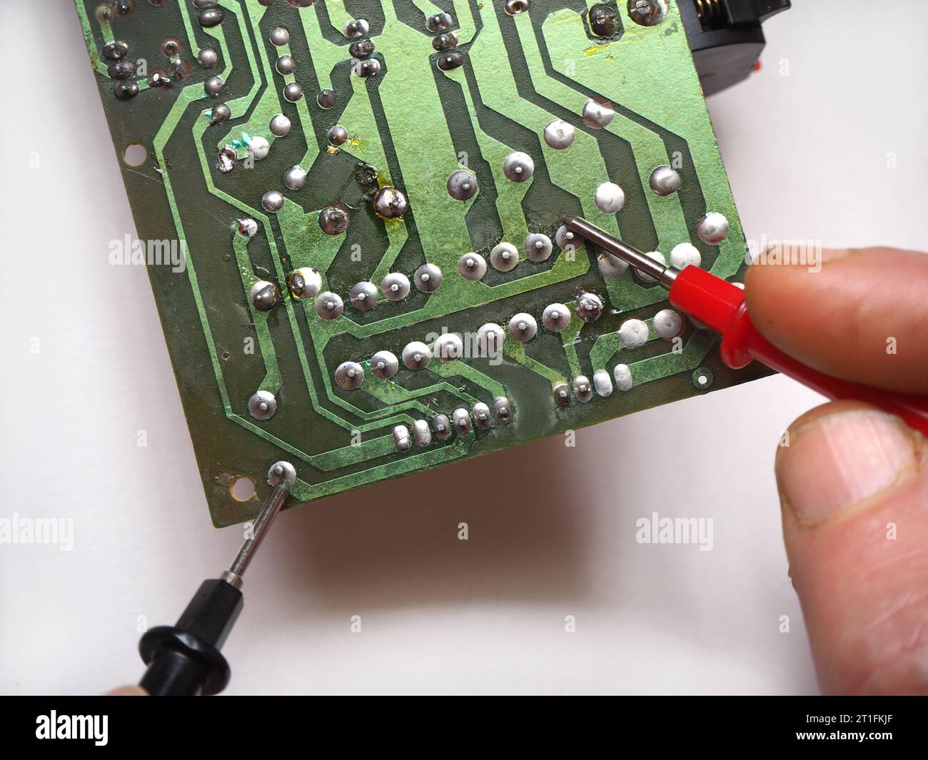 Repairman making measurements on electronic circuit board. Stock Photo