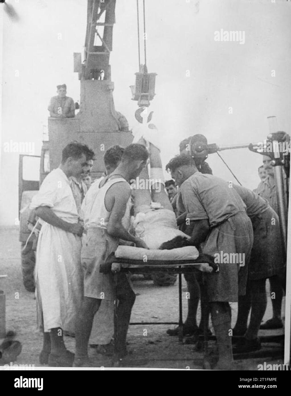 British Medical Services in the Second World War The Medical Chain of Evacuation: Emergency surgery on a soldier with a broken spine at a Field Dressing Station (FDS) in the Western Desert. A mobile crane is being used to lift the man into the correct position before a plaster cast can be applied. Stock Photo