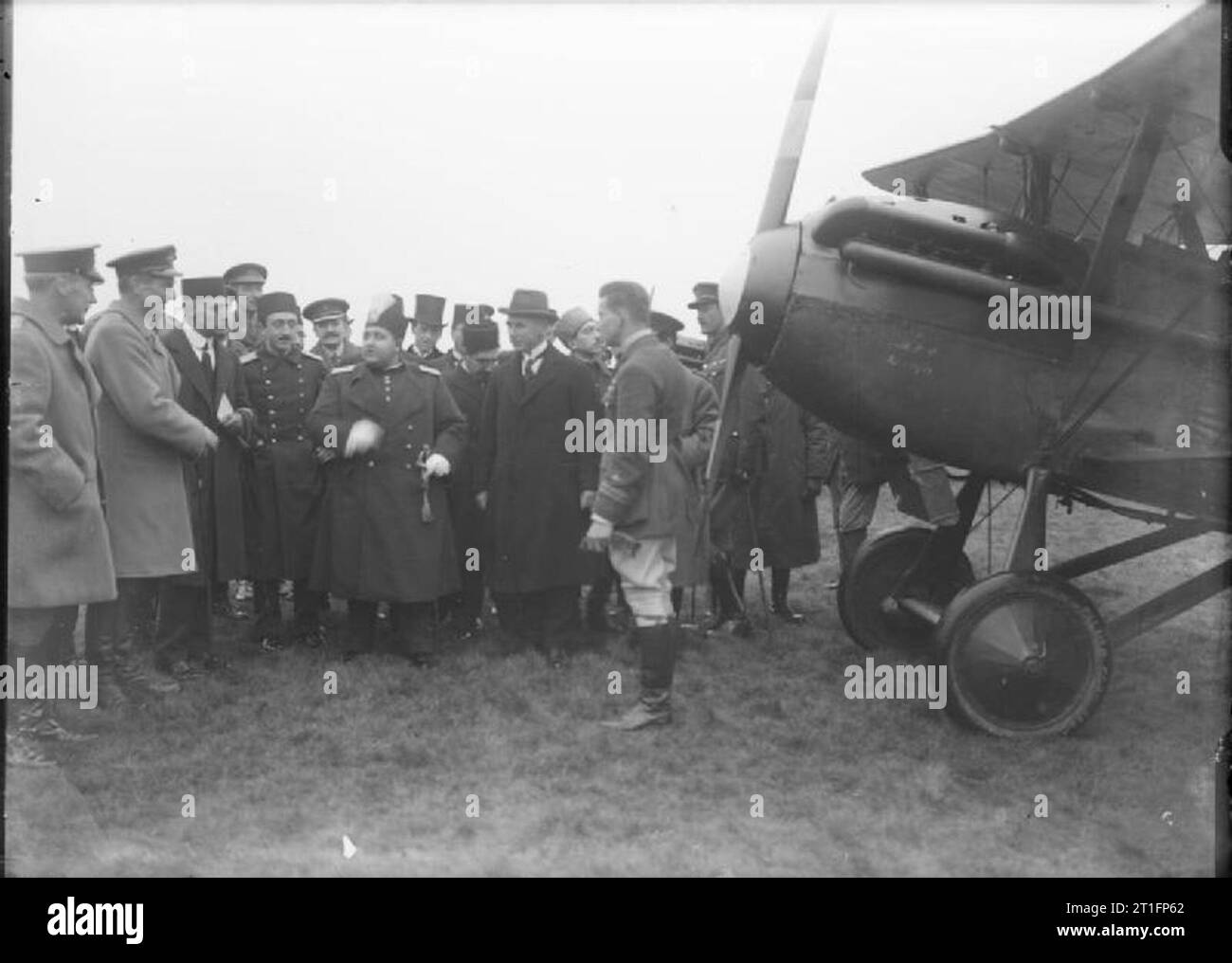 Aircraft and Balloons Used by Some of the Air Pioneers Who Were Contemporary With Samuel Franklin Cody. Ahmad Shah Qajar the former King of Iran and his ministers inspecting aircraft. In the foreground is a pilot stood next to the nose of his aircraft. On the left hand side of the photograph are two British officers. Stock Photo