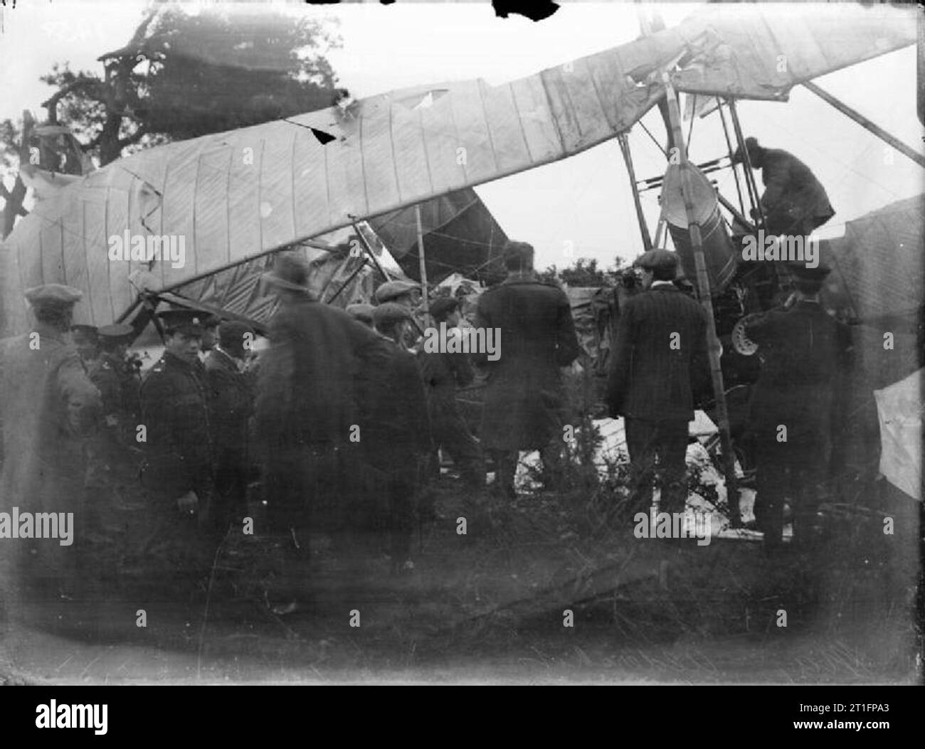 Aviation in Britain Before the First World War Either the Cody aircraft mark IIE (Omnibus - so named because of its passenger carrying capabilities) written off in amongst some trees after the pilot Lieut. J N Fletcher crashed it whilst coming in to land or the mark III after it hit a tree whilst the pilot Major H D Harvey-Kelly was landing. There are several civilian and army onlookers stood around inspecting the wreckage. In the case of the IIE Cody was a passenger in the aircraft as he was teaching Fletcher to fly at the time. Cody broke his shin bone as well as being badly bruised and conc Stock Photo