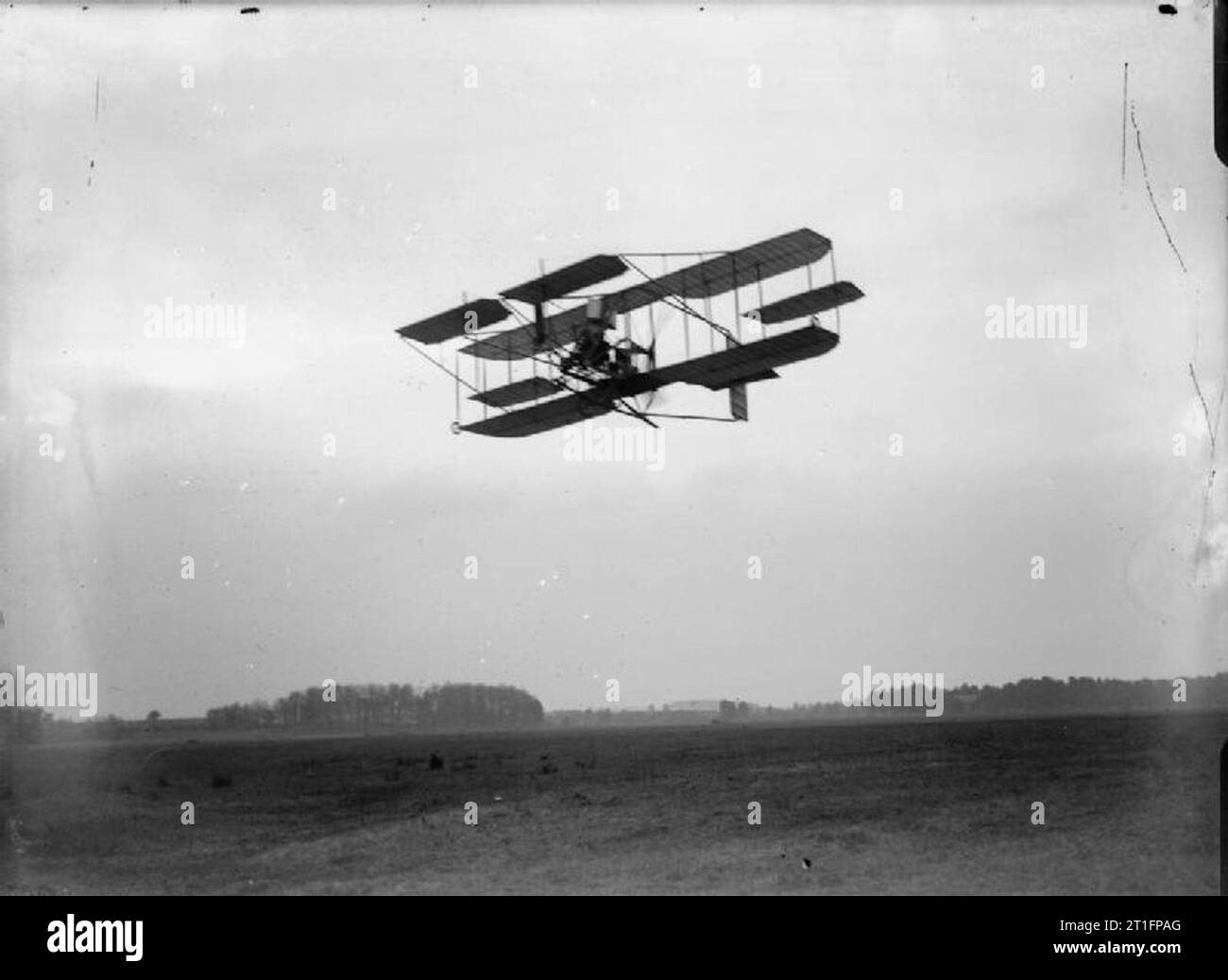 Aviation in Britain Before the First World War Cody aircraft mark II flying over Laffan's Plain. What looks like Cody's workshop can be seen amongst the trees in the background. Cody built this aircraft in 1910; the previous aircraft had been in several crashes and was suffering generally from constant usage. The design of this aircraft followed similar lines to the previous one though the wingspan was shorter by around six feet and the wing area around a third smaller. The single propeller was originally intended to be powered by two 60 hp Green engines (mark IIA) though problems with synchro Stock Photo