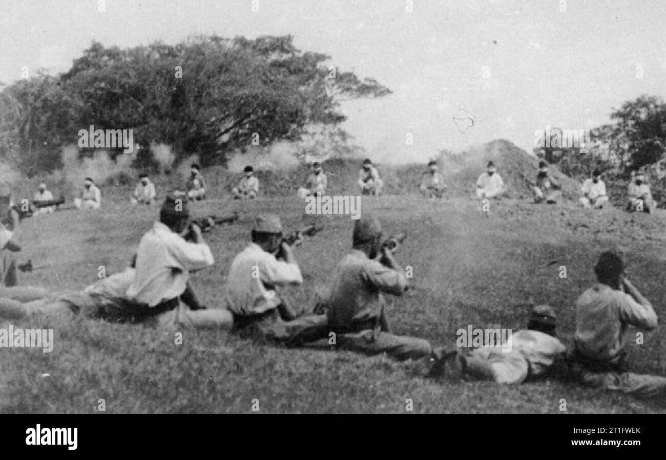 ATROCITIES CARRIED OUT BY JAPANESE FORCES DURING THE SECOND WORLD WAR WAR OFFICE, CENTRAL OFFICE OF INFORMATION AND AMERICAN SECOND WORLD WAR OFFICIAL COLLECTION Japanese soldiers shooting Sikh prisoners who are sitting blindfolded in a rough semi-circle about 20 yards away. Four photographs found among Japanese records when British troops entered Singapore. Picture number 3 (here) shows:- The shots ring out. Some appear to be near misses, and none at this stage appear to be fatal. Stock Photo