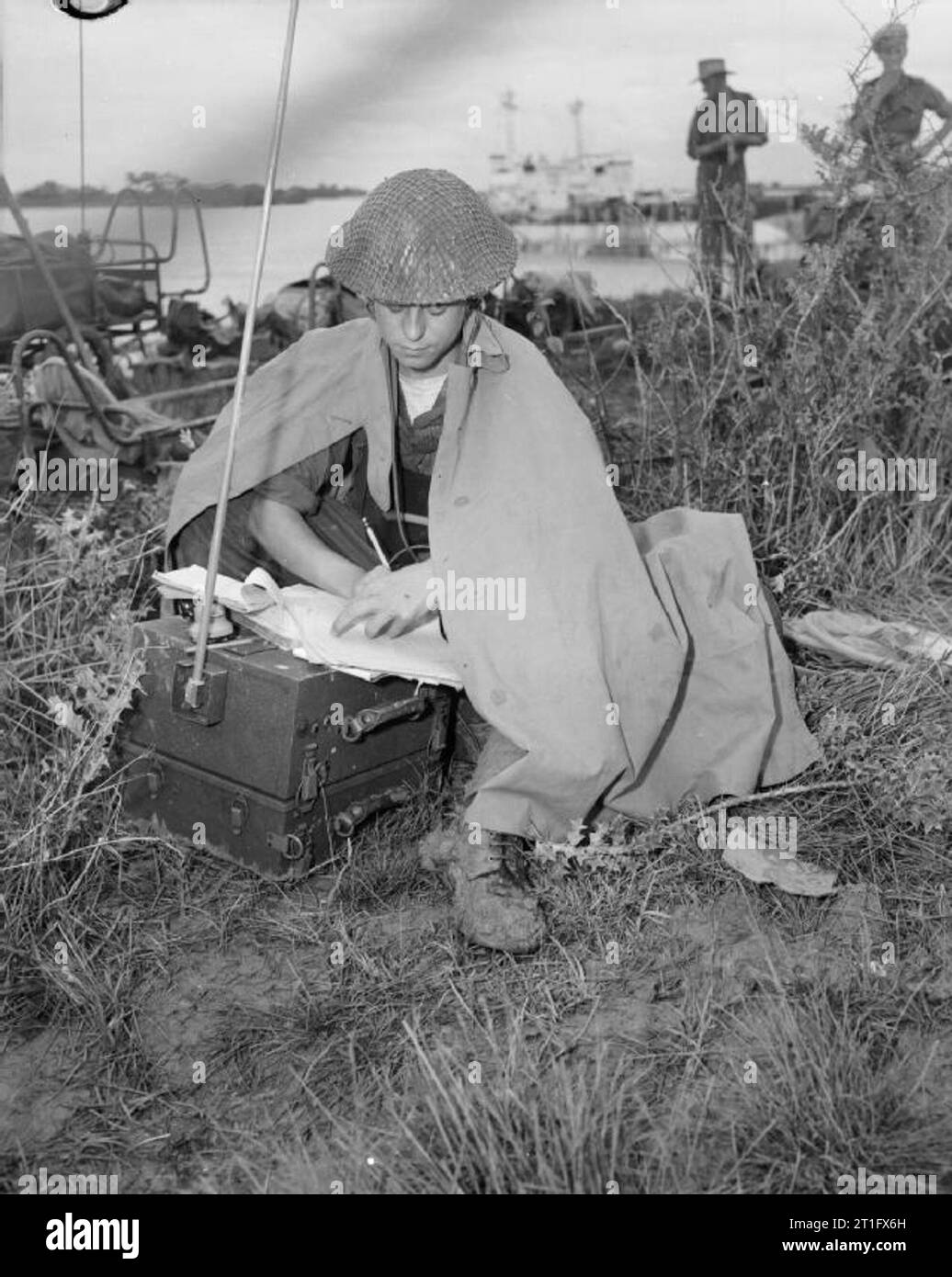 The British Army in Burma 1945 Telegraphist Brindle transmitting messages in the rain shortly after landing south of Rangoon at the beginning of Operation 'Dracula', 3 May 1945. Stock Photo