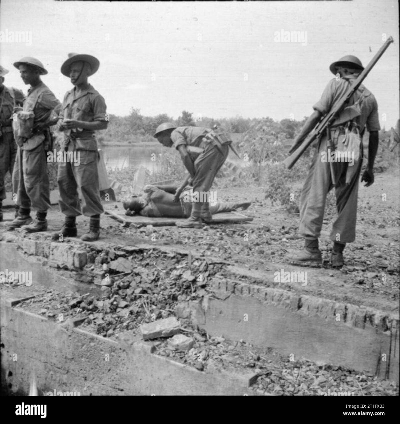 The British Occupation of Java Soldiers of the 5th Indian Division wait for a casualty to be evacuated after a skirmish with Indonesian nationalists outside of Surabaya (Soerabaja). Although British and Indian forces secured the town after heavy fighting the surrounding countryside continued to harbour many fighters armed with discarded Japanese weapons. Stock Photo