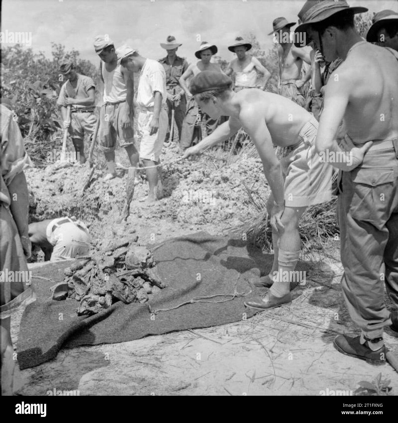 The British Reoccupation of Singapore Captain R S Ross of the Royal Army Medical Corps examines a piece of cloth found with the body of an Allied prisoner of war exhumed by Japanese prisoners during a search for evidence of Japanese atrocities for the war crimes trials held at Singapore. It was thought the piece of cloth may have been used as a blindfold prior to the man being executed. Stock Photo