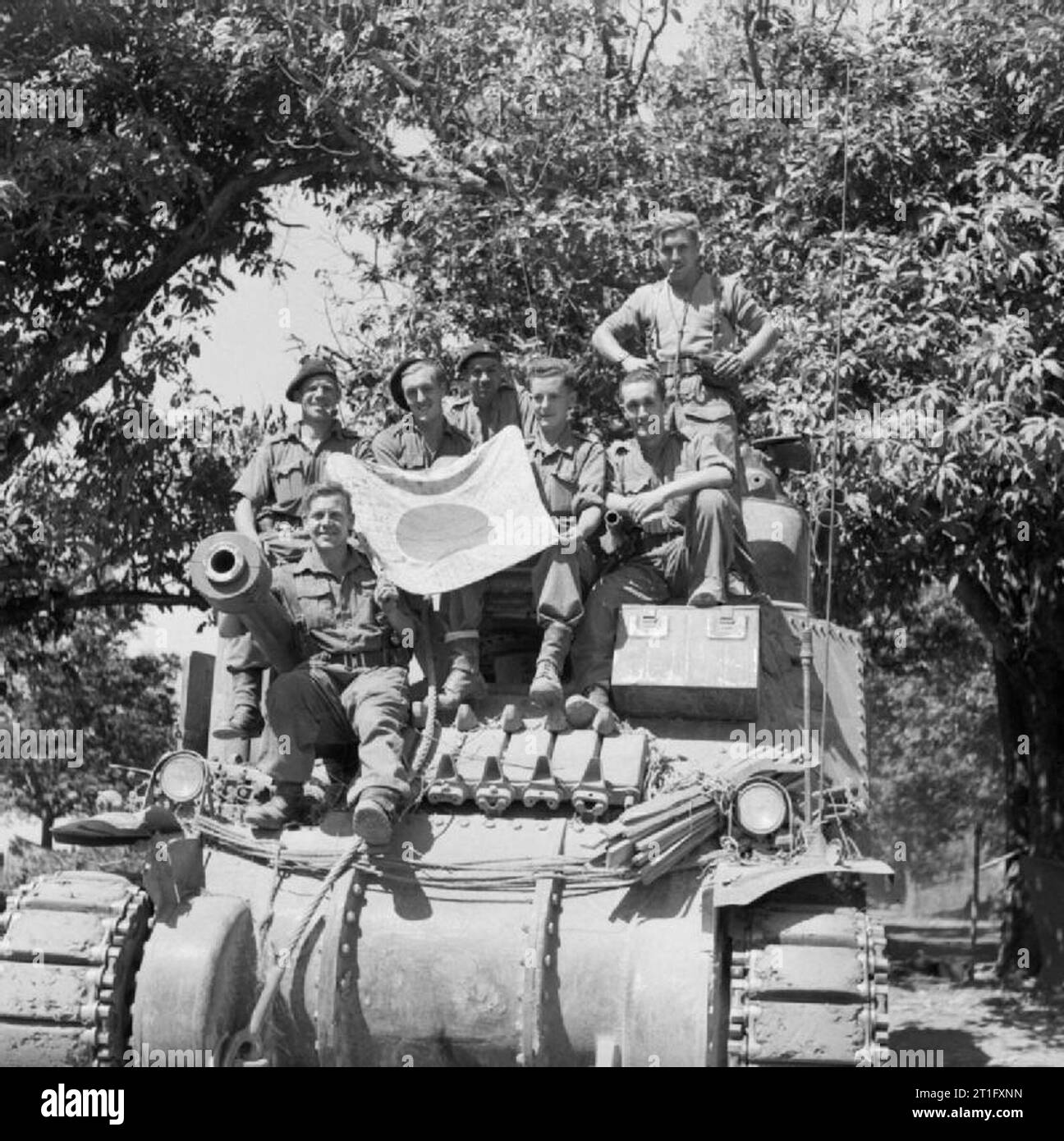 The crew of a Lee tank pose with a captured Japanese flag during the ...