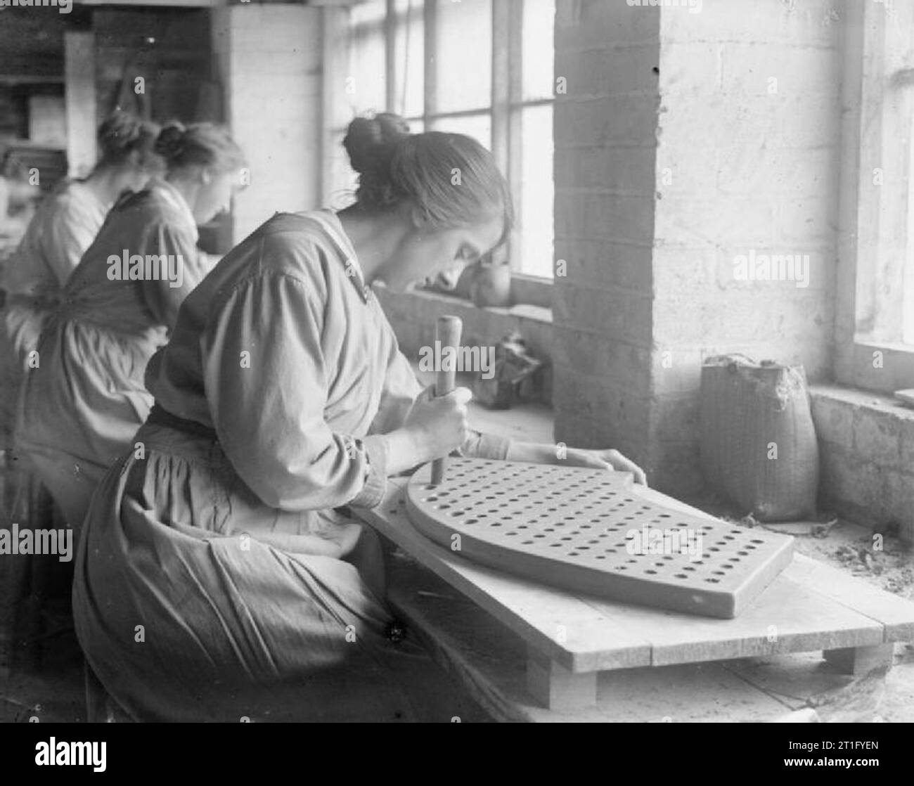 Industry during the First World War- Leicestershire A female worker prepares a plate for vibrating pans used in the production of gun cotton at the Hathern Station Brick and Terracotta Company Ltd, Hathern, Leicestershire, in September 1918. Stock Photo