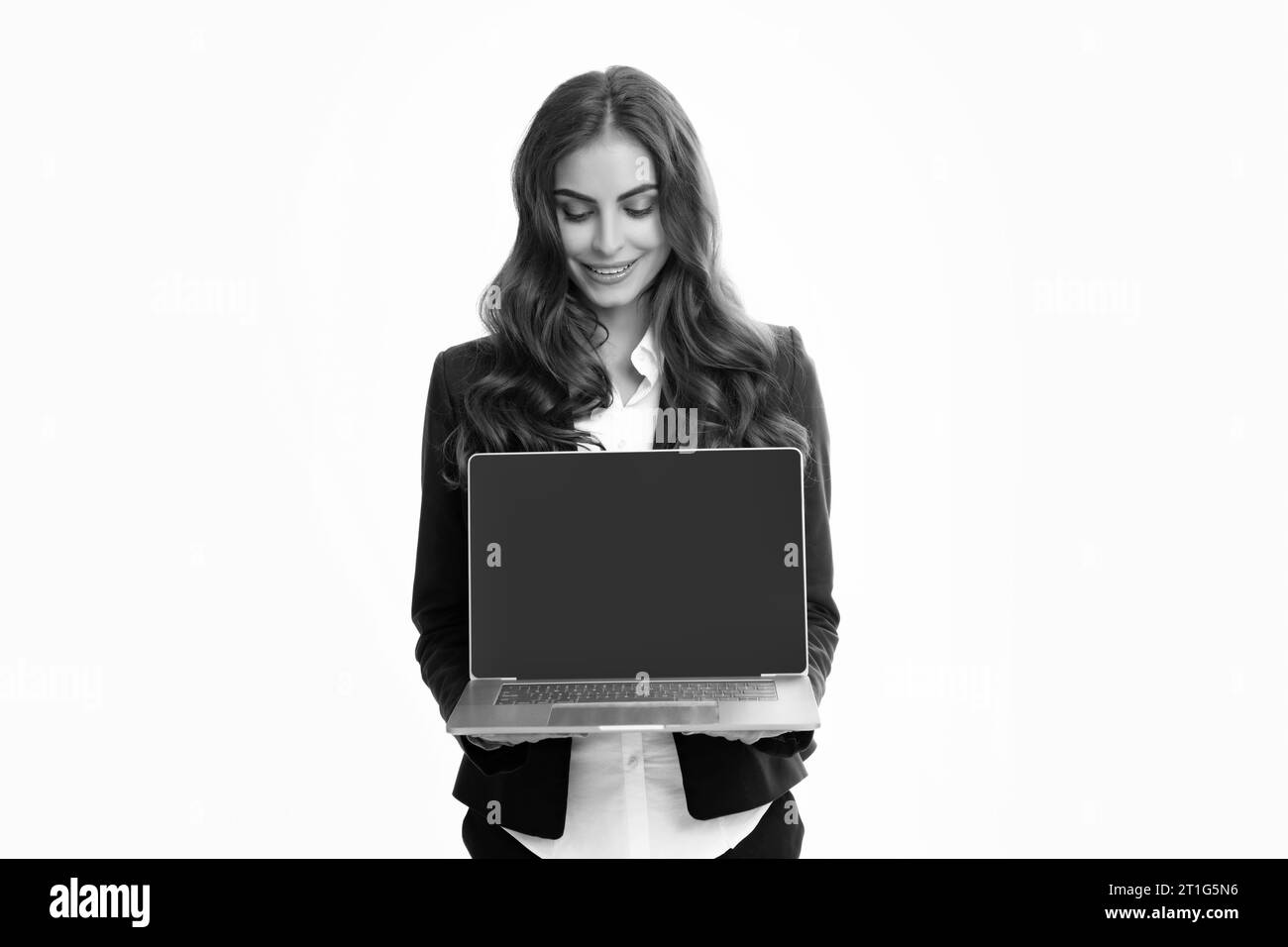 Portrait of young businesswoman using laptop computer isolated on gray background. Business women in suit excited something in laptop screen. Portrait Stock Photo