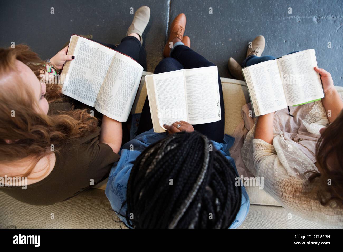 Three woman sitting on a couch with open Bibles. Stock Photo