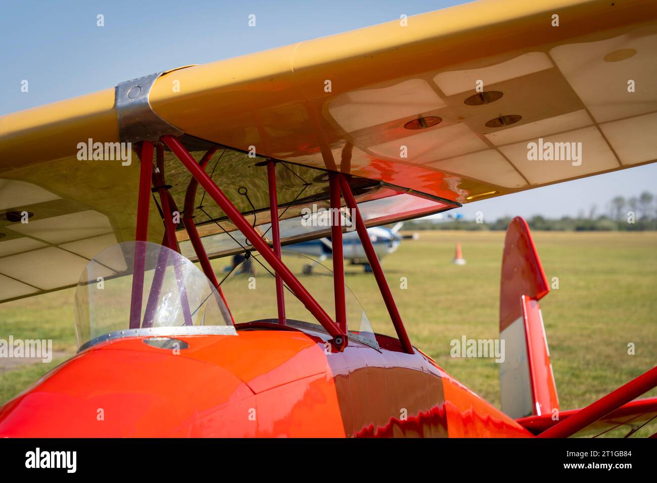 Red painted glider on a grassy airfield Stock Photo