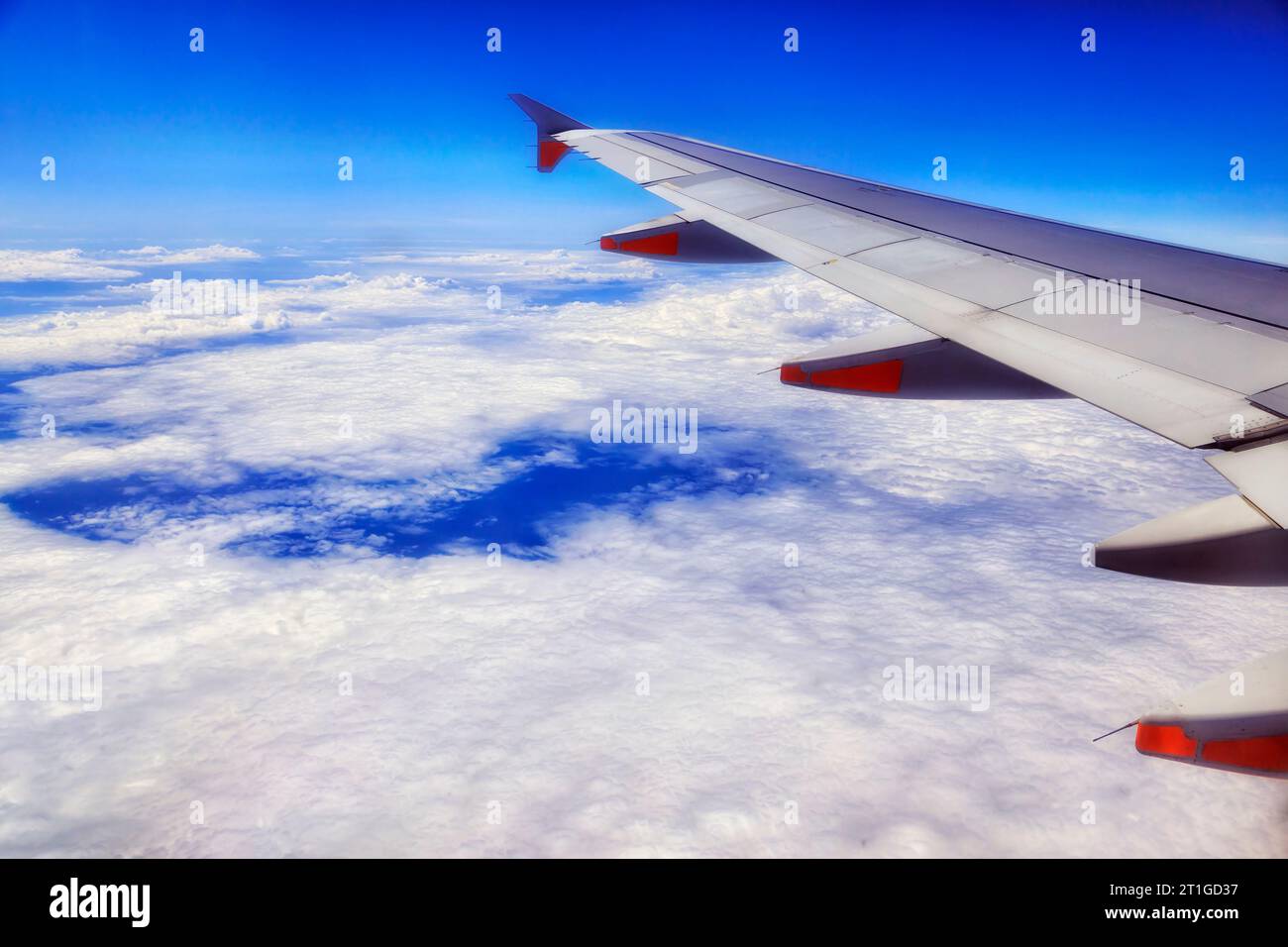 Passenger airplane wing with engines flying over Pacific ocean cloudscape to Australia from New Zealand. Stock Photo