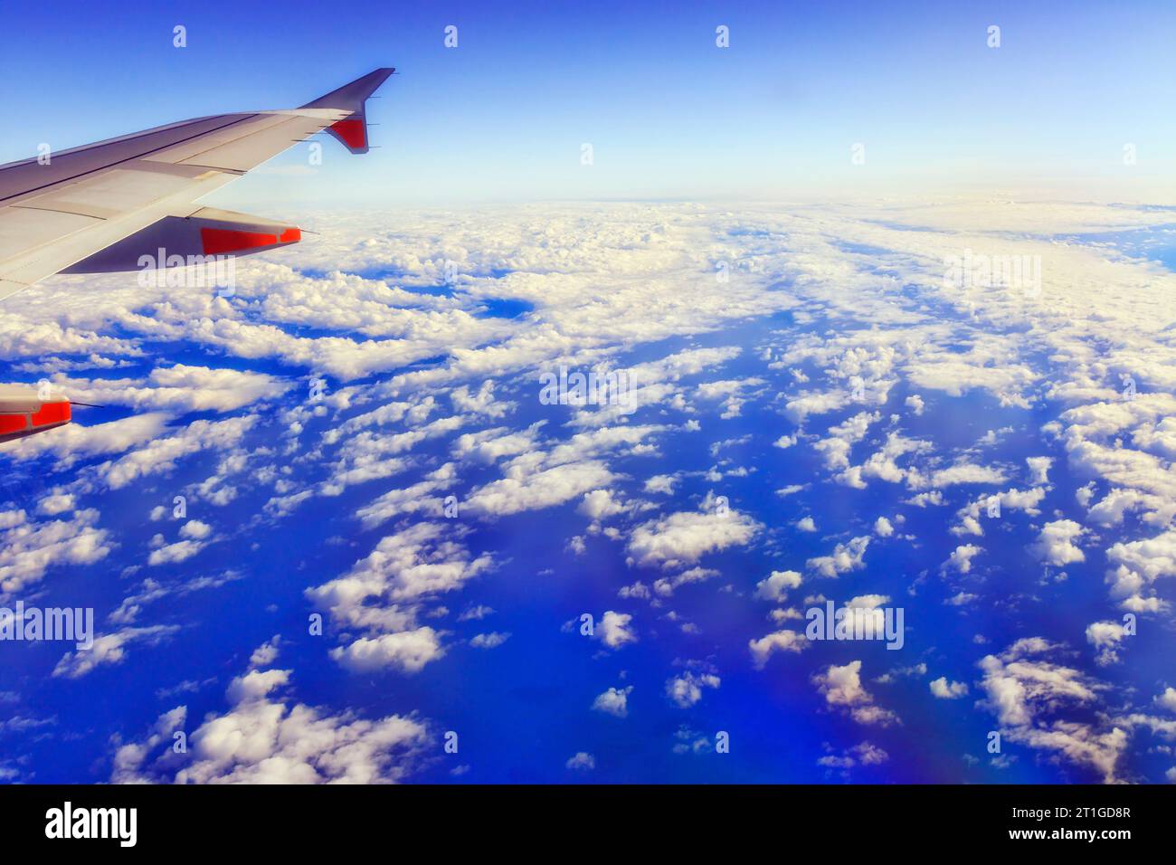 High altitude on board of airplane over Tasman Sea of Pacific ocean over clouds. Stock Photo