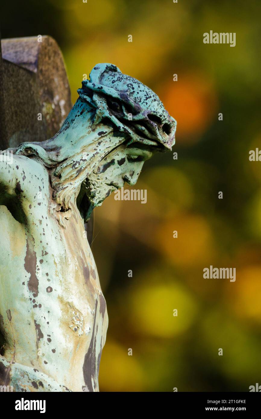 close up of crucifix in profile in front of autumn forest in blurred background Stock Photo