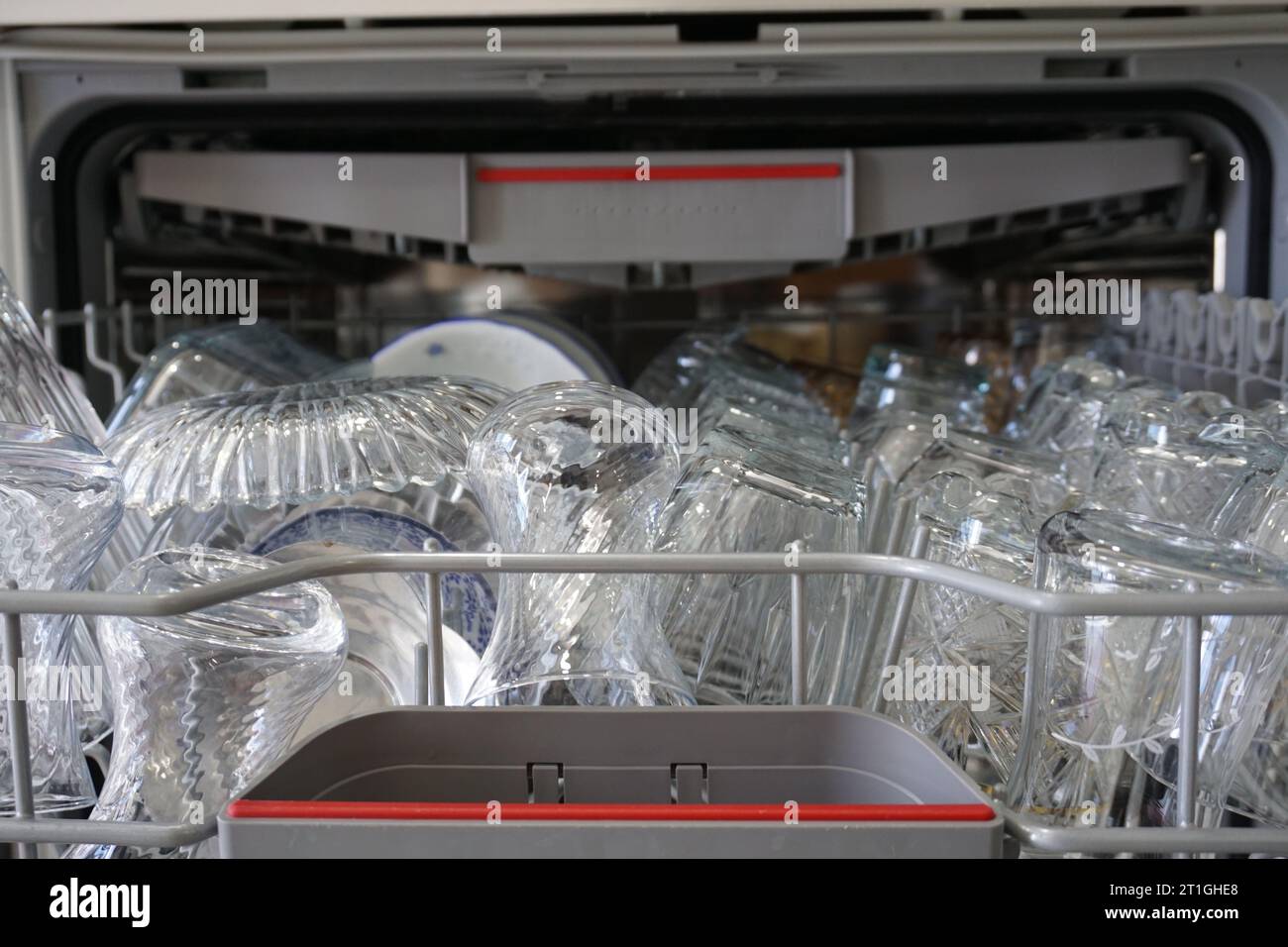 Inside the dishwasher. Washed dishes are on the shelf. Cleaned dishes