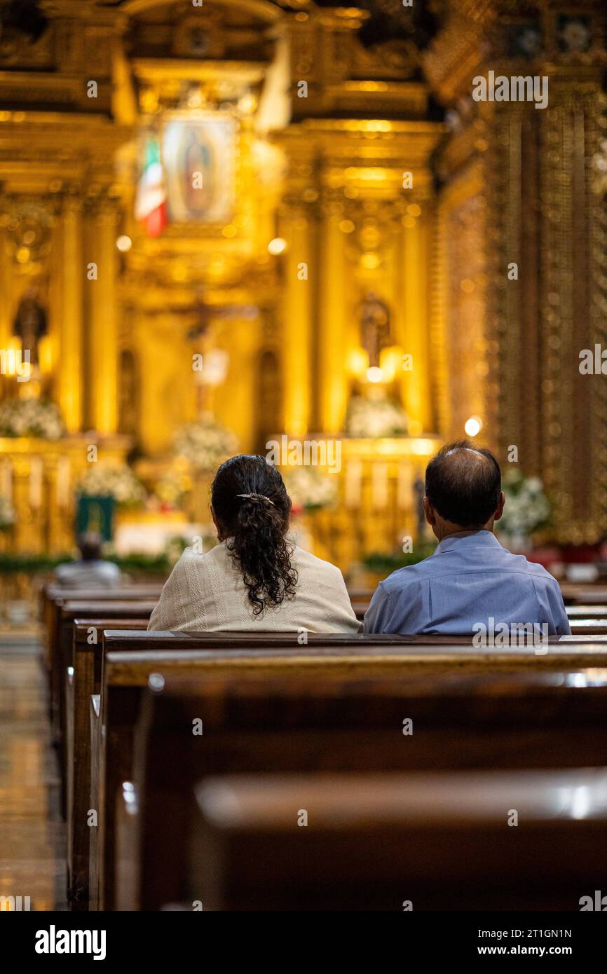 Middle aged couple at mass in the Temple of San Diego in Morelia, Michoacan, Mexico. Stock Photo