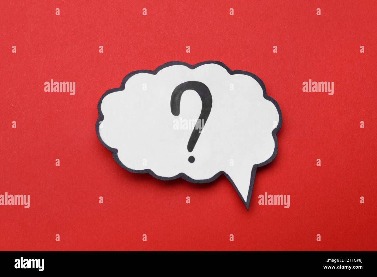 Paper speech bubble with question mark on red background, top view Stock Photo