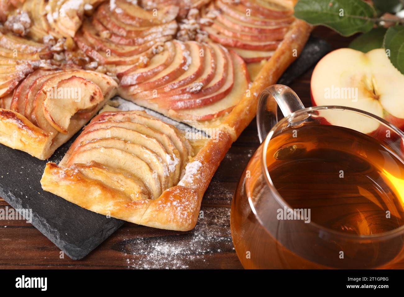 Freshly baked apple pie served with tea on wooden table, closeup Stock Photo