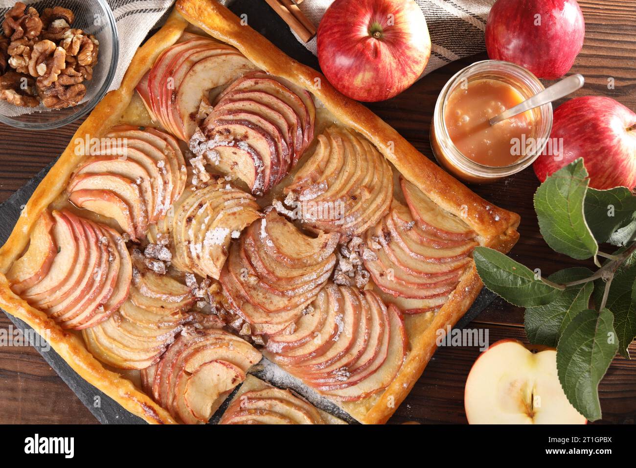 Freshly baked apple pie and ingredients on wooden table, flat lay Stock Photo