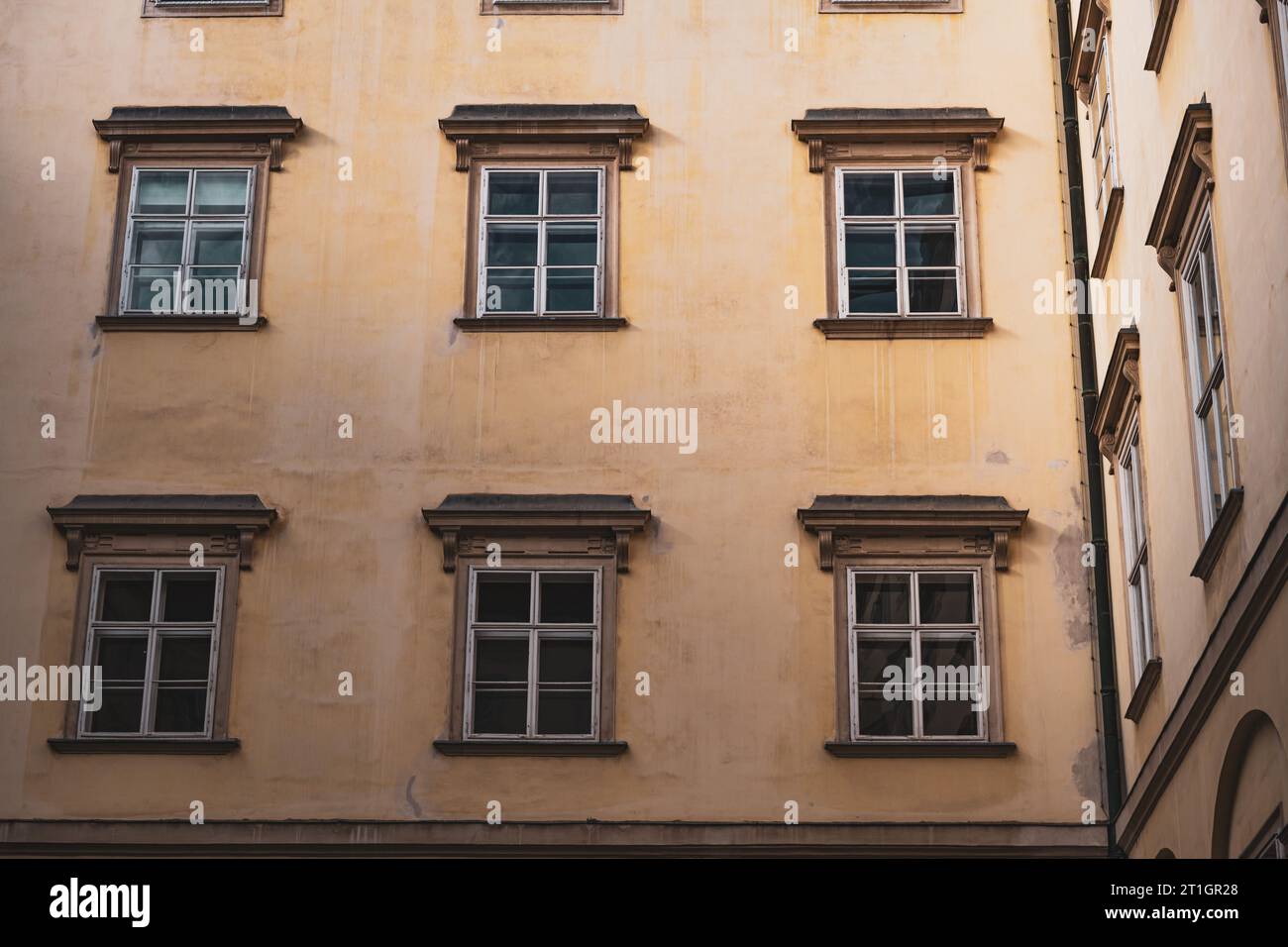 A vintage yellow building with various windows in Vienna, Austria Stock Photo