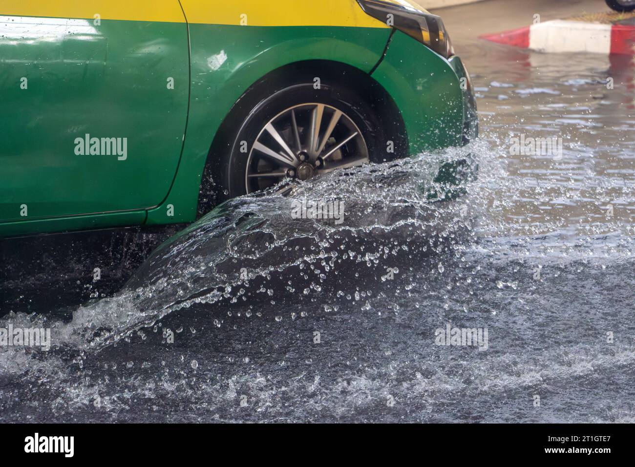 The detailed look at wheel of car driving through a flooding street the rain Stock Photo
