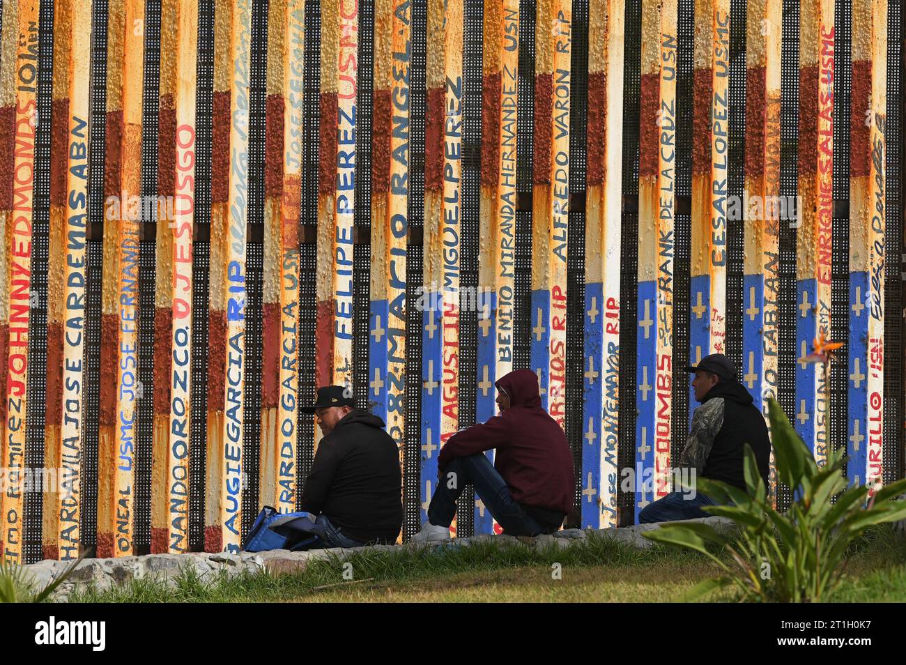 Tijuana, Baja California, Mexico. 13th Oct, 2023. Migrants wait along a mural of an upside down US flag at Tijuana's beach border where new replacement primary fencing is being installed at the US-Mexico border on Friday, October 13, 2023. The fence panels will be 30 feet as the secondary fencing that has already been completed. (Credit Image: © Carlos A. Moreno/ZUMA Press Wire) EDITORIAL USAGE ONLY! Not for Commercial USAGE! Stock Photo