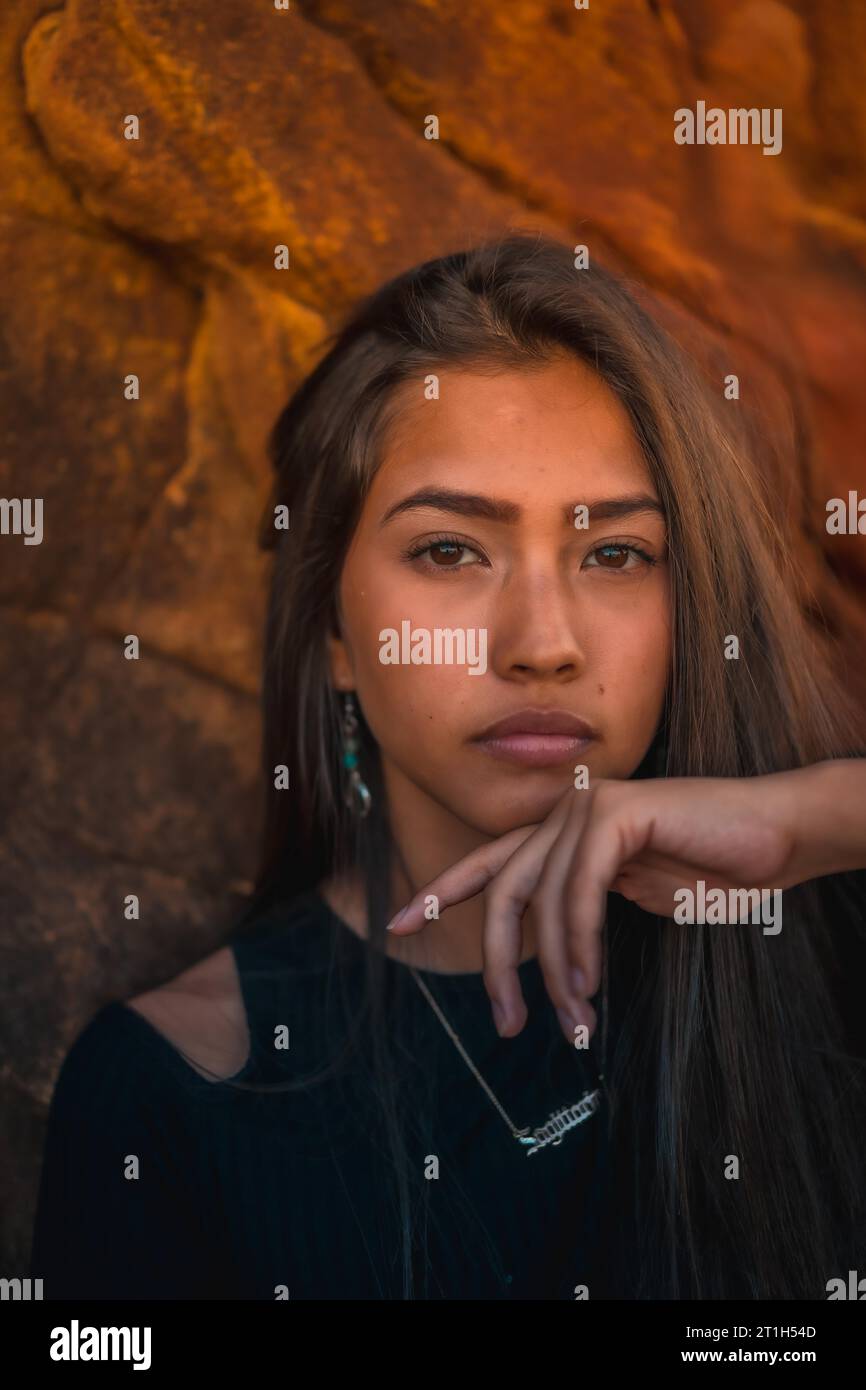 A young pretty brunette Latina with long straight hair in a short black T-shirt and pink pants