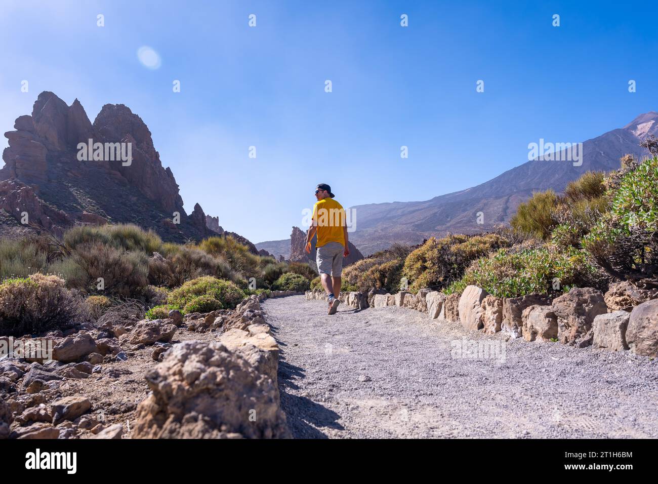 A tourist walking on the path between Roques de Gracia and Roque Cinchado in the natural area of Teide in Tenerife, Canary Islands Stock Photo