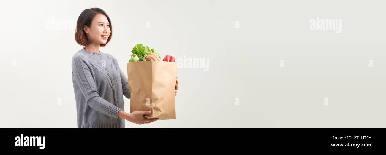 Asian woman with paper bag of fresh vegetable isolated on white background Stock Photo