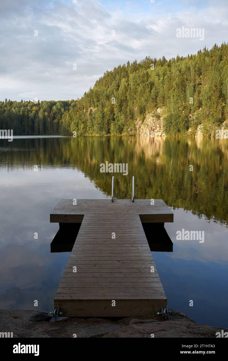 Wooden pier on a lake in Southern Konnevesi National Park, Finland. Summer landscape with the reflection. Stock Photo
