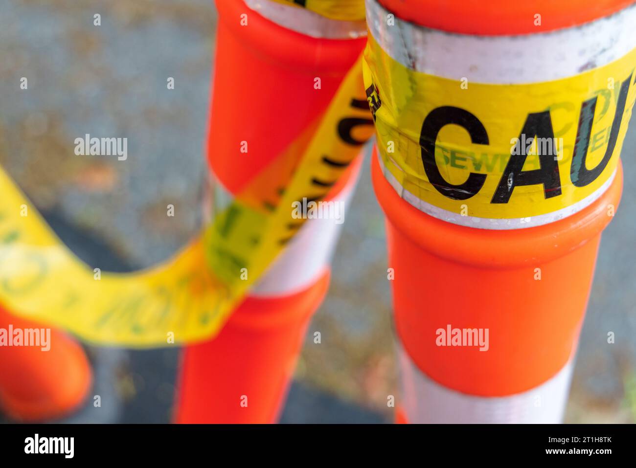 Yellow tape with the word "Caution" hangs from orange and white