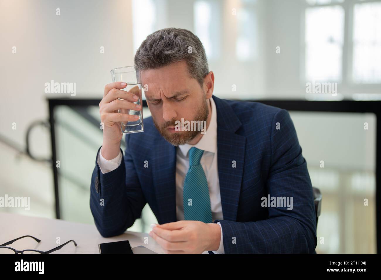 Overworked burnout man feeling migraine head strain. Tired bored business man has office syndrome. Man taking a Medicine pill from headache migraine Stock Photo