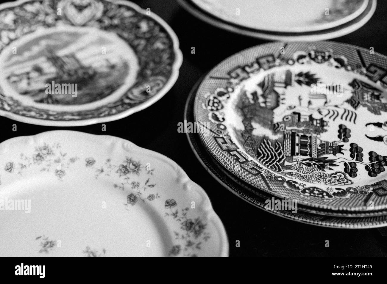 A collection of dinner plates with intricate designs, in grayscale