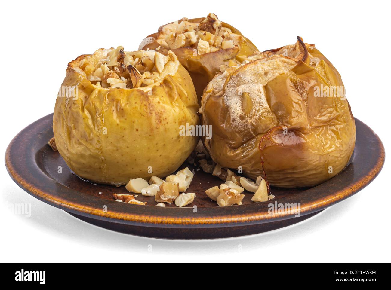 baked apples with nuts on a ceramic brown plate, white background Stock Photo