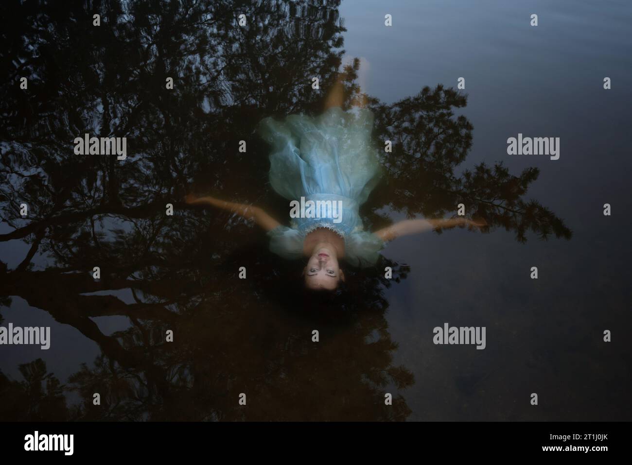 a girl in a blue dress under the water.suicide of a woman on the lake. Stock Photo
