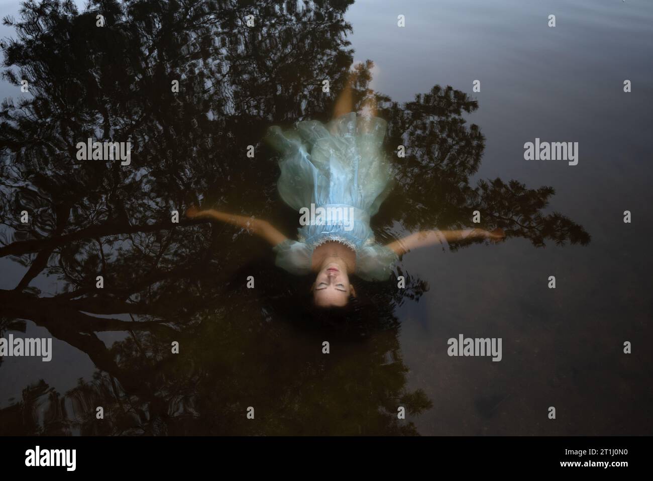 a girl in a blue dress under the water.suicide of a woman on the lake. Stock Photo