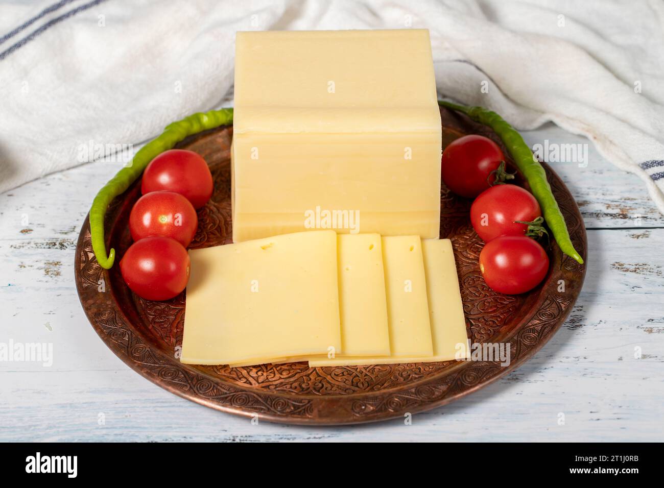Fresh cheese or kashkaval in a copper plate. Fresh cheddar cheese on wooden background. local name kasar peyniri. Close up Stock Photo
