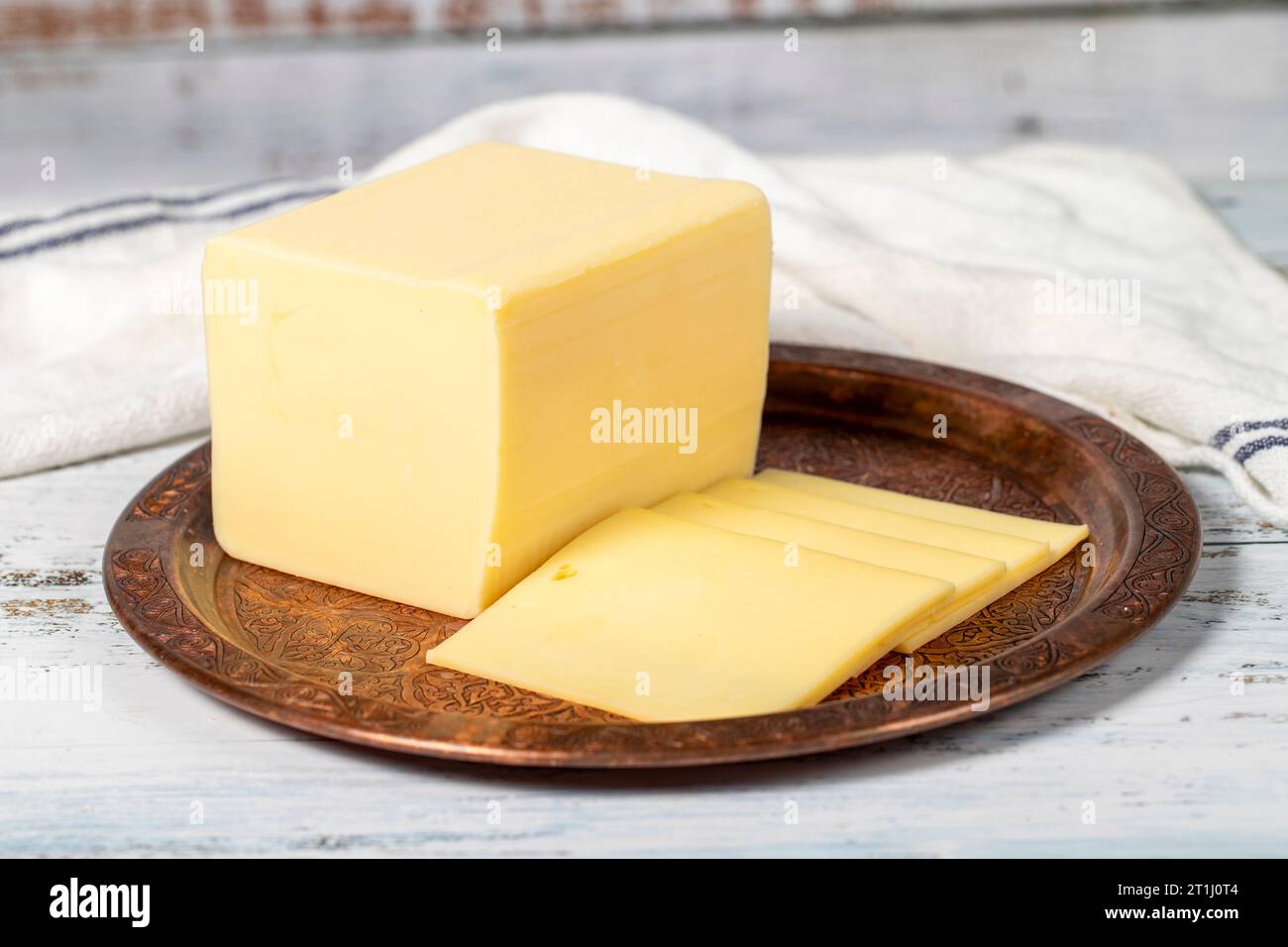 Fresh cheese or kashkaval in a copper plate. Fresh cheddar cheese on wooden background. local name kasar peyniri. Close up Stock Photo