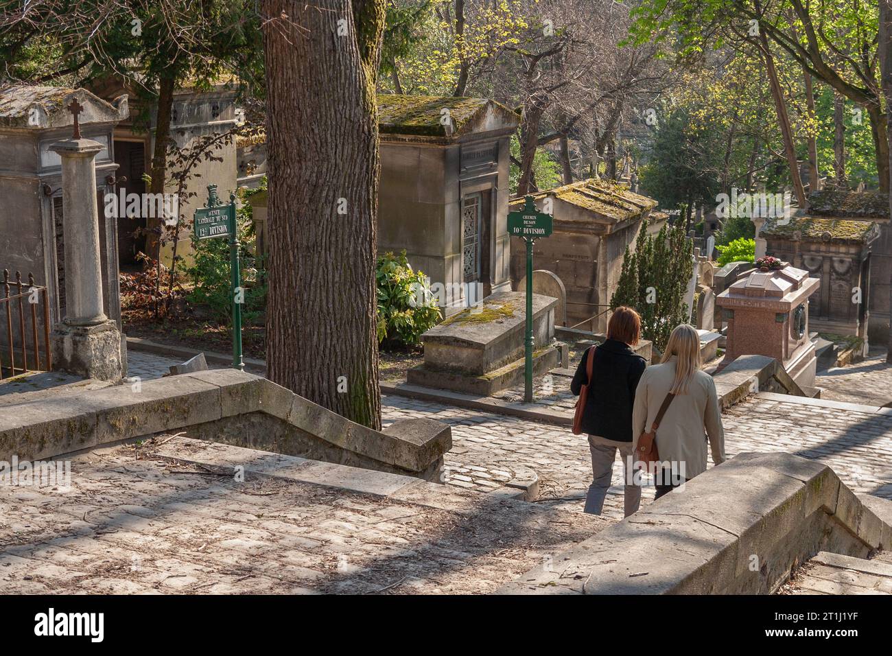 Two women walk through Père Lachaise Cemetery, Paris, France Stock Photo