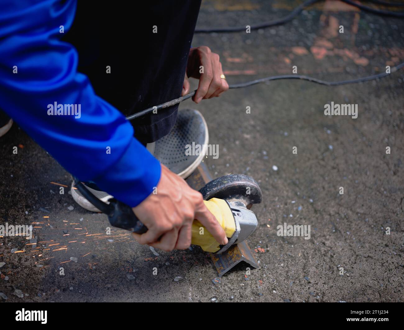 Industrial Worker Using Angle Grinder and Cutting a Metal Stock Photo