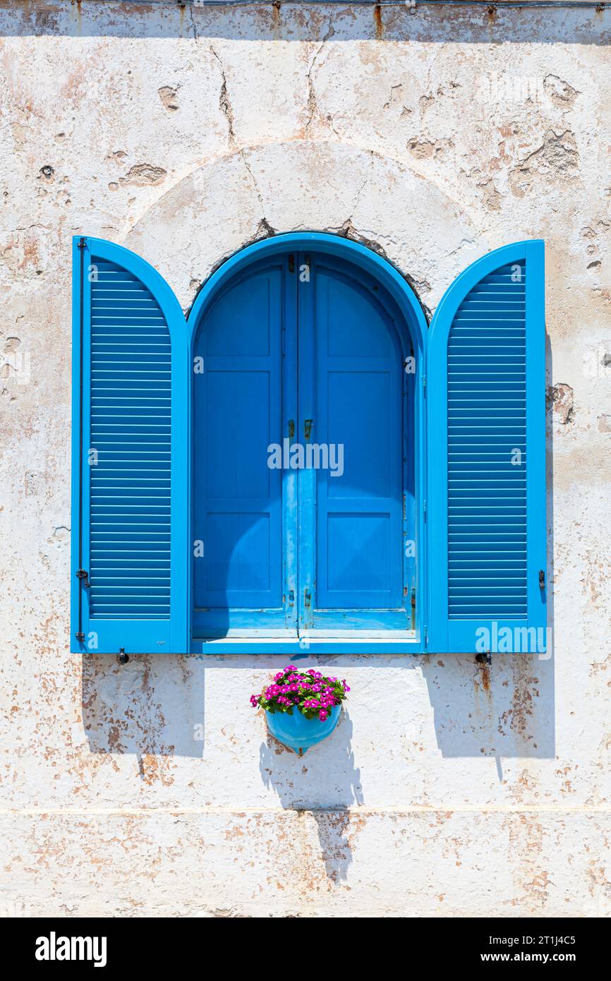 A window with blue shutters in Santa Maria di Leuca, a village on the Adriatic coast on the southern tip of the Salento peninsula in southern Italy Stock Photo