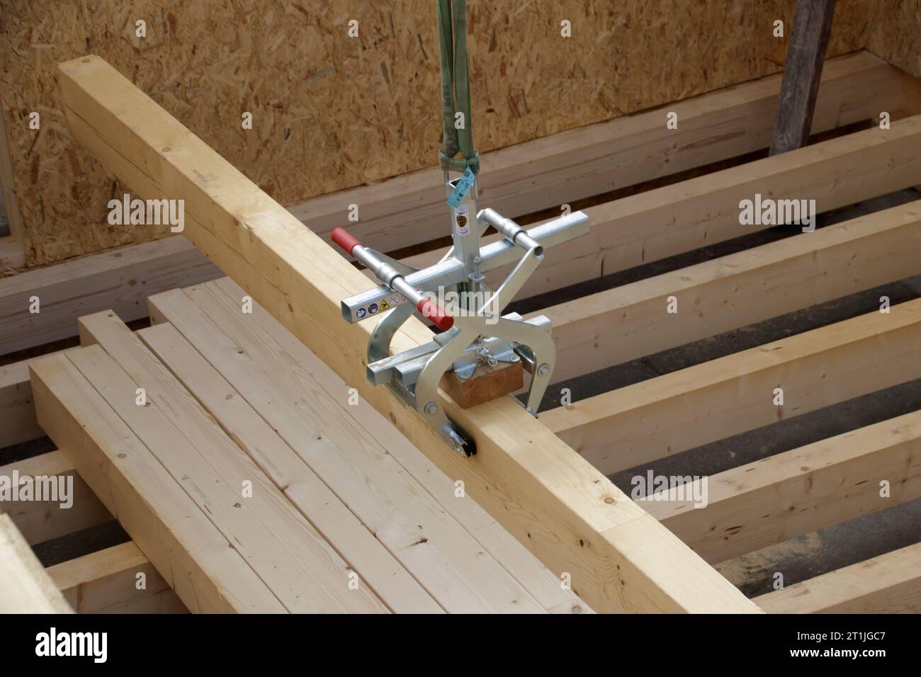 Wooden beam is transported with lifting tongs Stock Photo Alamy