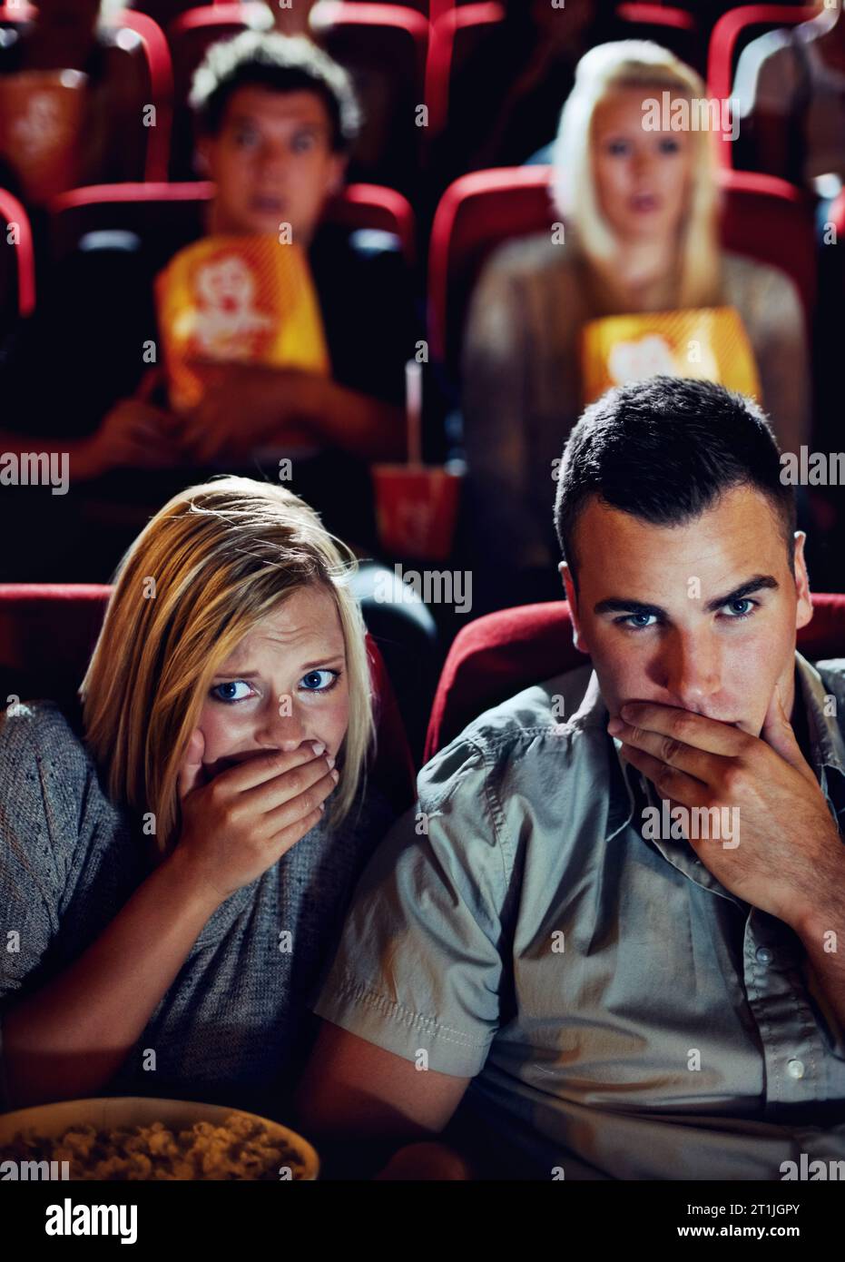 Cinema, shock and couple with popcorn, watching film or eating on