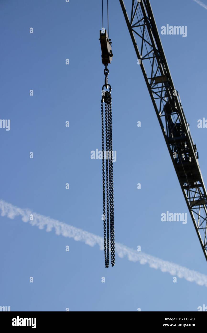 Boom of a construction crane in front of a contrail Stock Photo