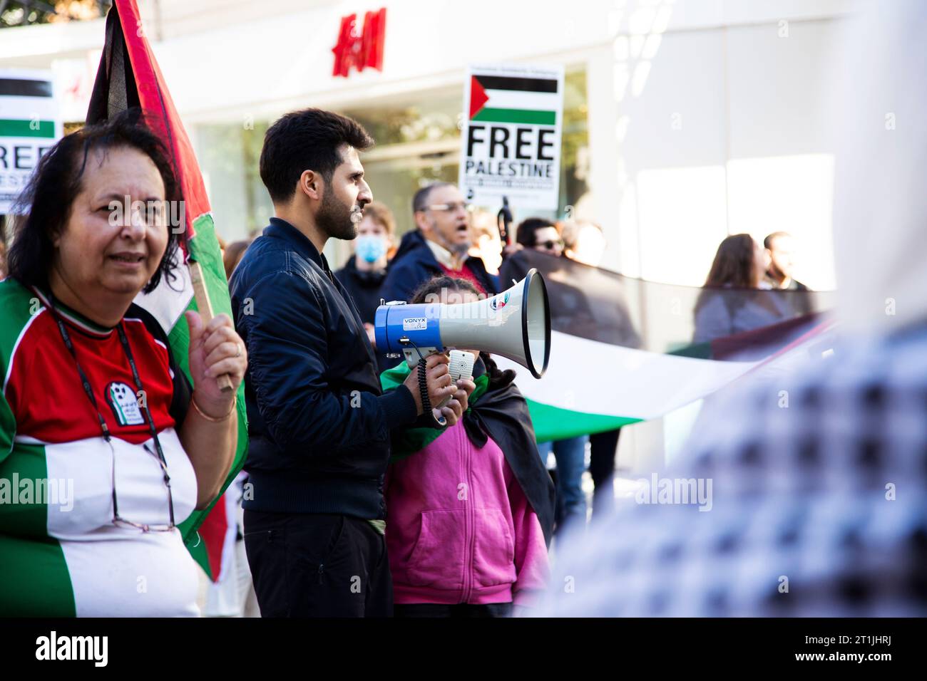 Free Palestine protest Exeter city centre - man and young girl protest on megaphone walk around Stock Photo