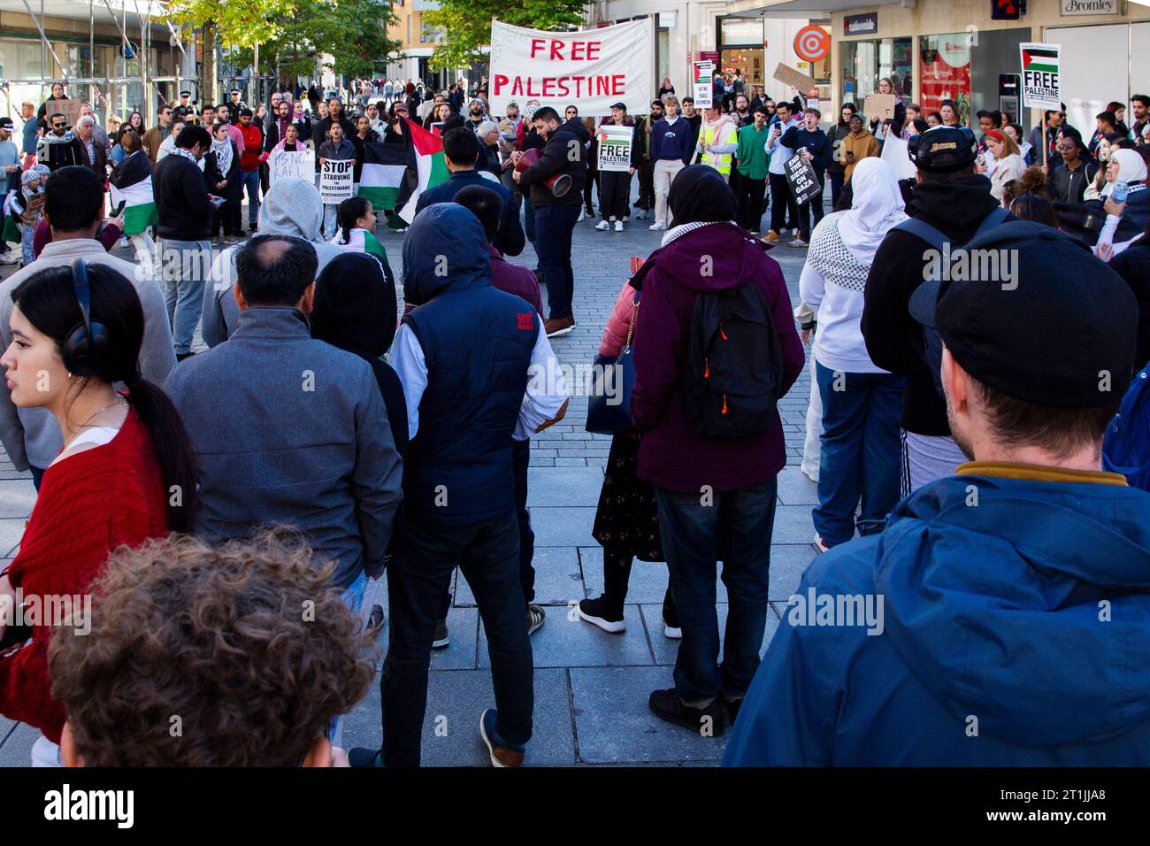 Free Palestine protest Exeter - large crowd stand in circle with protestors speaking into mega phone in the centre and with musical percussion Stock Photo