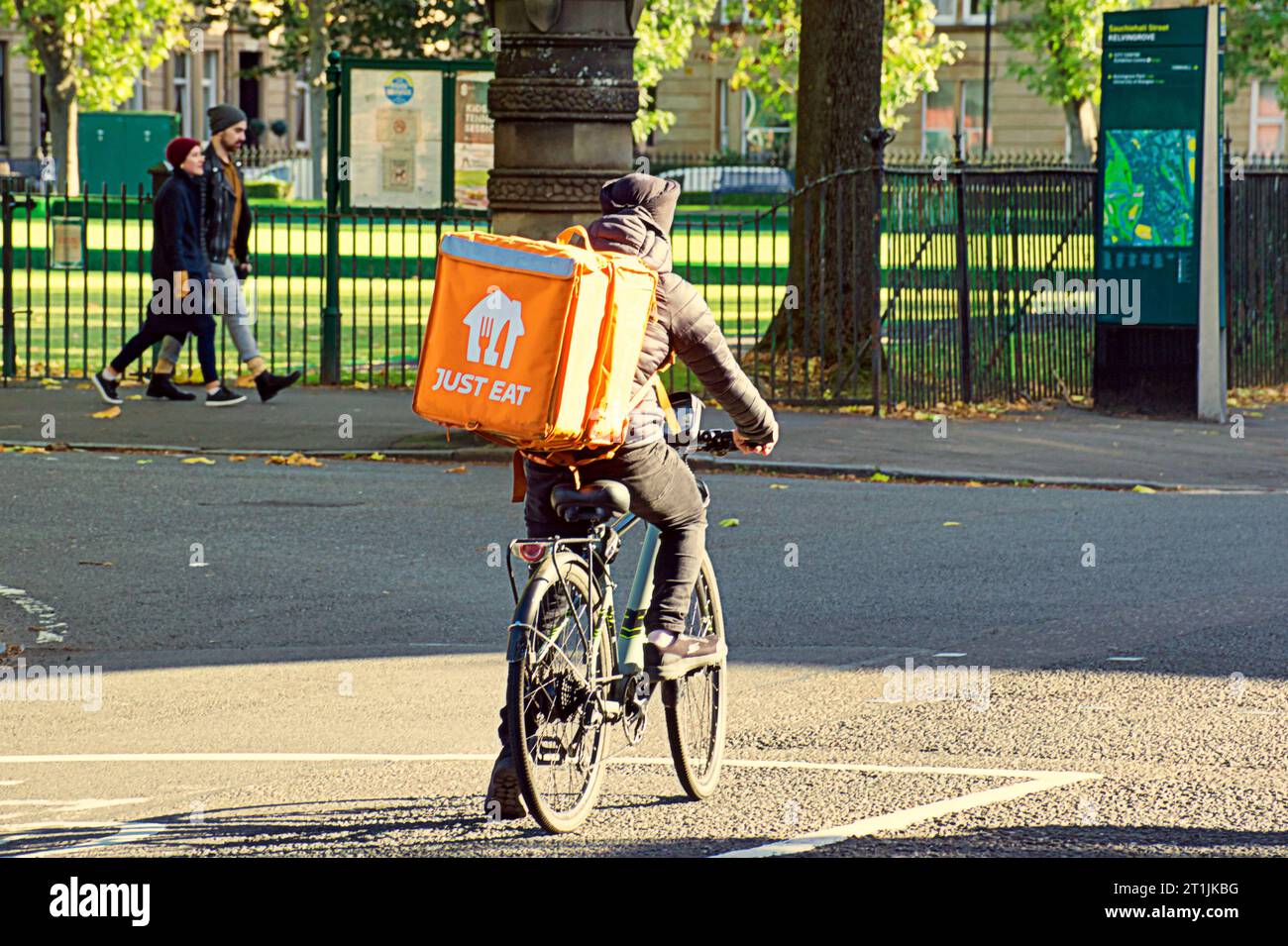 Glasgow, Scotland, UK. 14th October, 2023. UK Weather: Sunny autumnal colour saw the west end’s just eat delivery cyclist on university avenue  in the sun. Credit Gerard Ferry/Alamy Live News Stock Photo