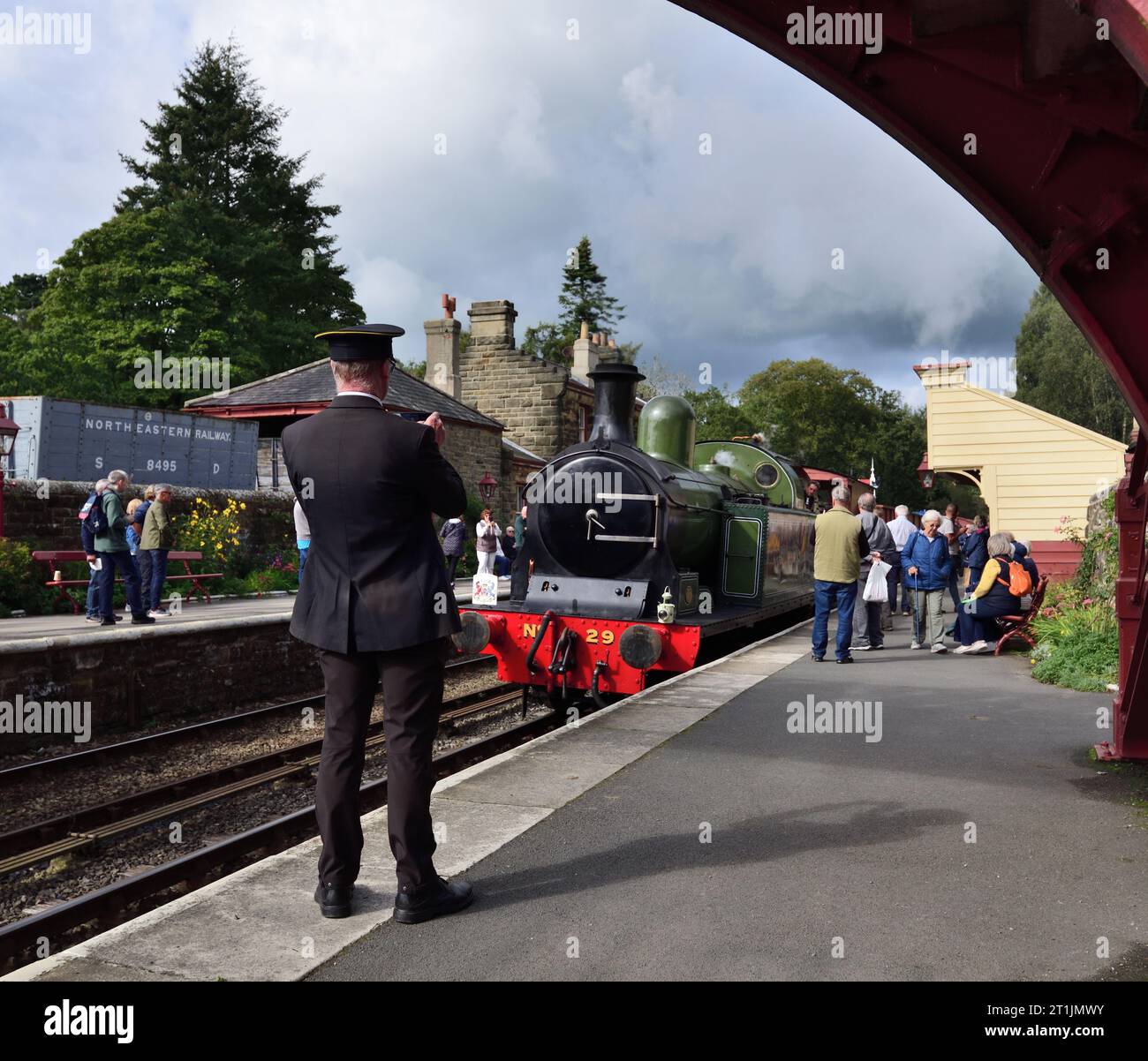 People watching a steam train arriving at Goathland station on the ...
